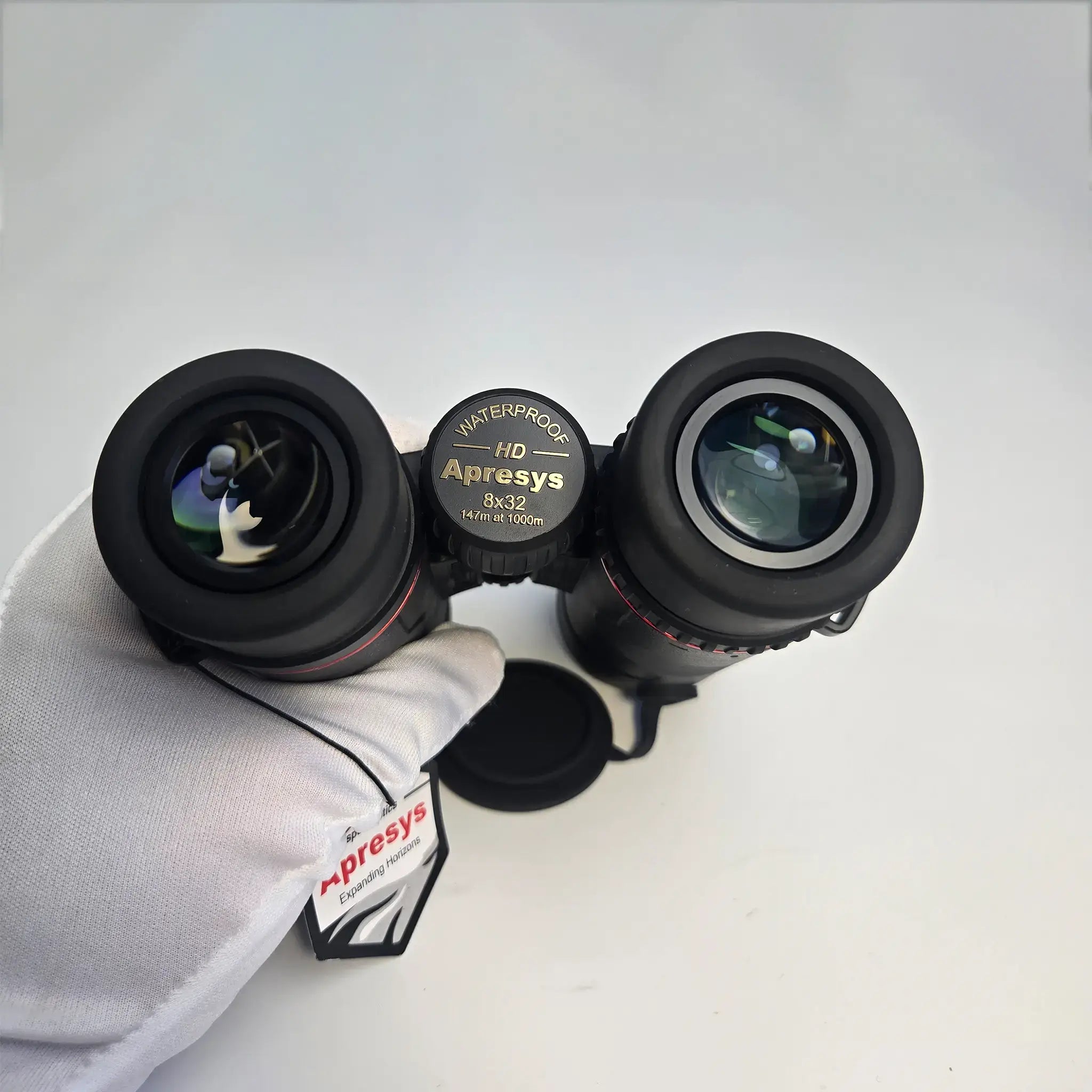 close-up view of APRESYS H0832 8x32 ED binoculars eyepiece and focus wheel showing waterproof, HD and 147m at 1000m markings