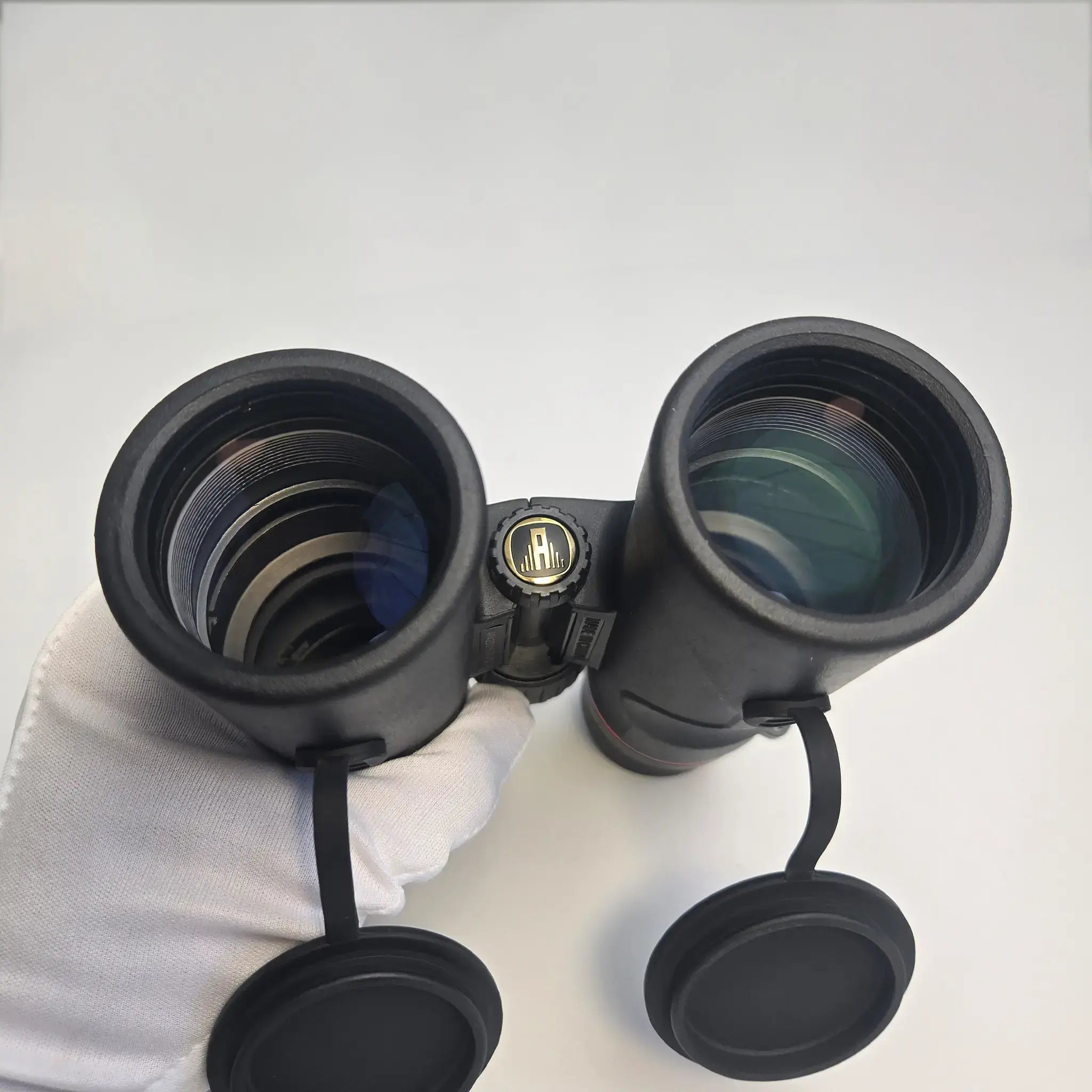 close-up of APRESYS H1042ED 10x42 ED binoculars objective lens showing FMC multi-coated glass for enhanced light transmission and optical clarity
