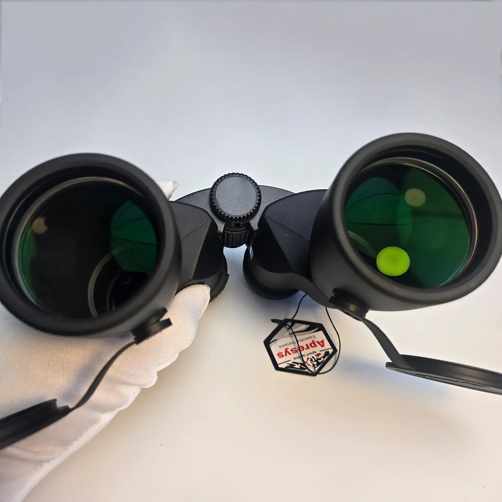 close-up of APRESYS M5010 10x50 ED binoculars objective lenses showing reflective fully multi-coated optical glass detail